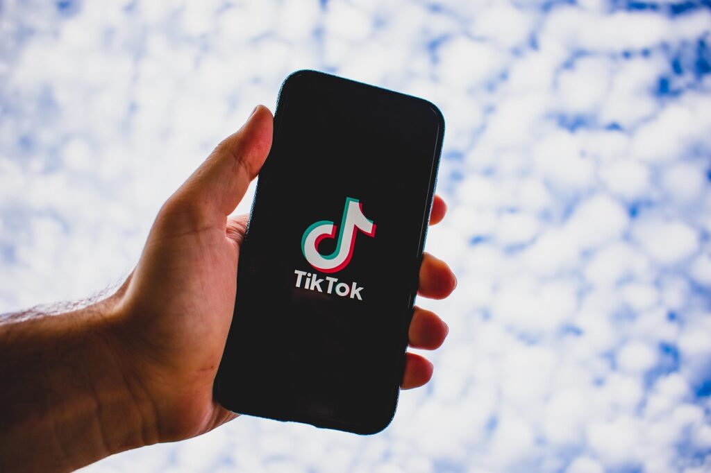 Person hält Handy in die Luft mit dem TikTok App